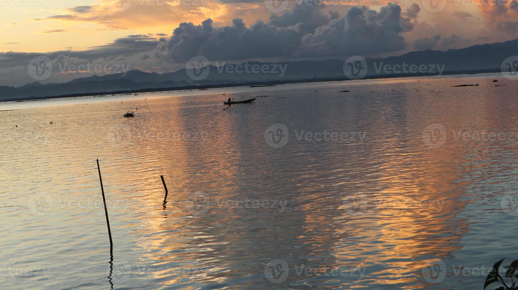 pescador em seu barco ao pôr do sol. barco de pescadores ao pôr do sol foto