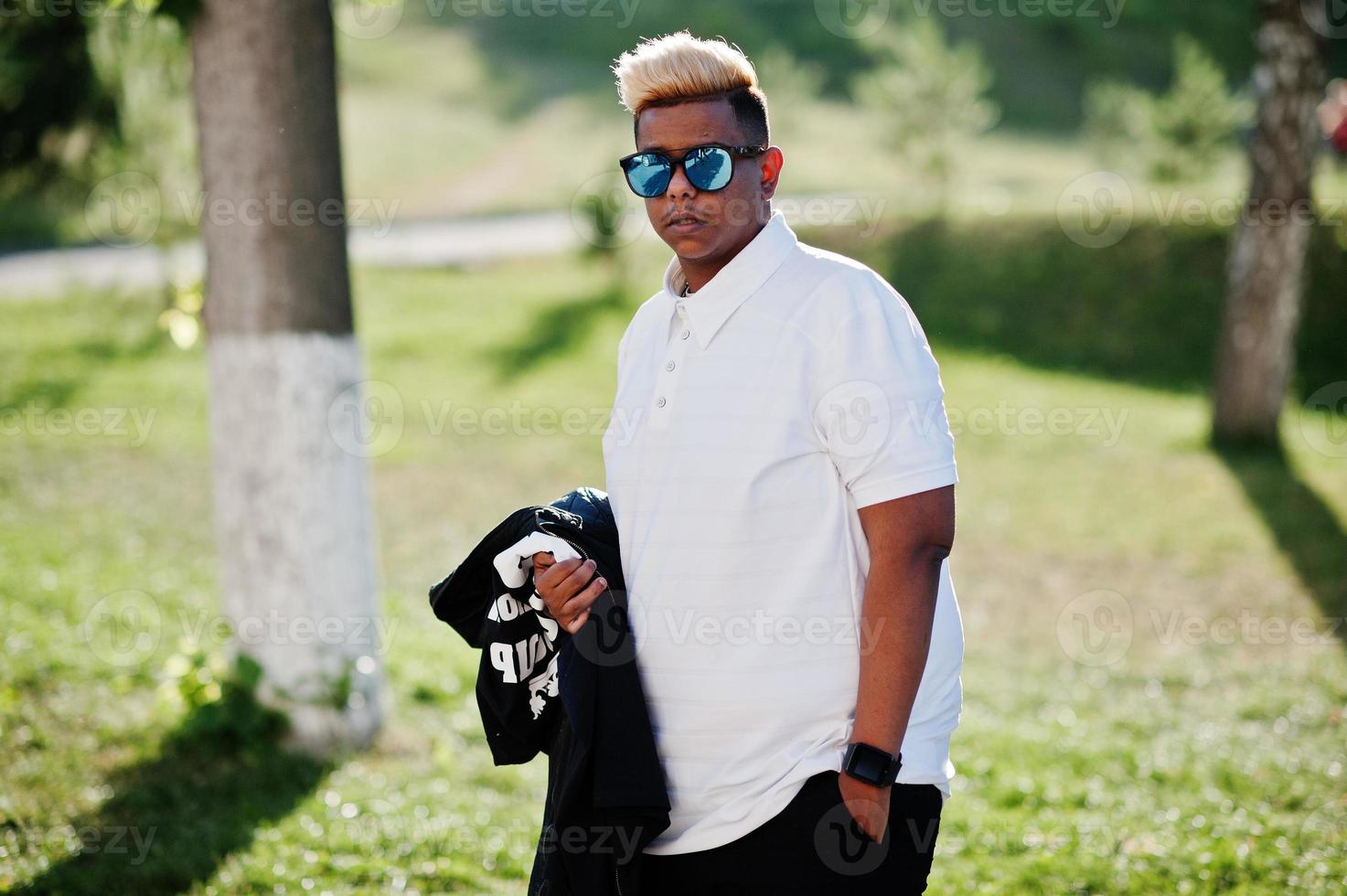 menino muçulmano árabe elegante com cabelo originalmente posado nas ruas. foto