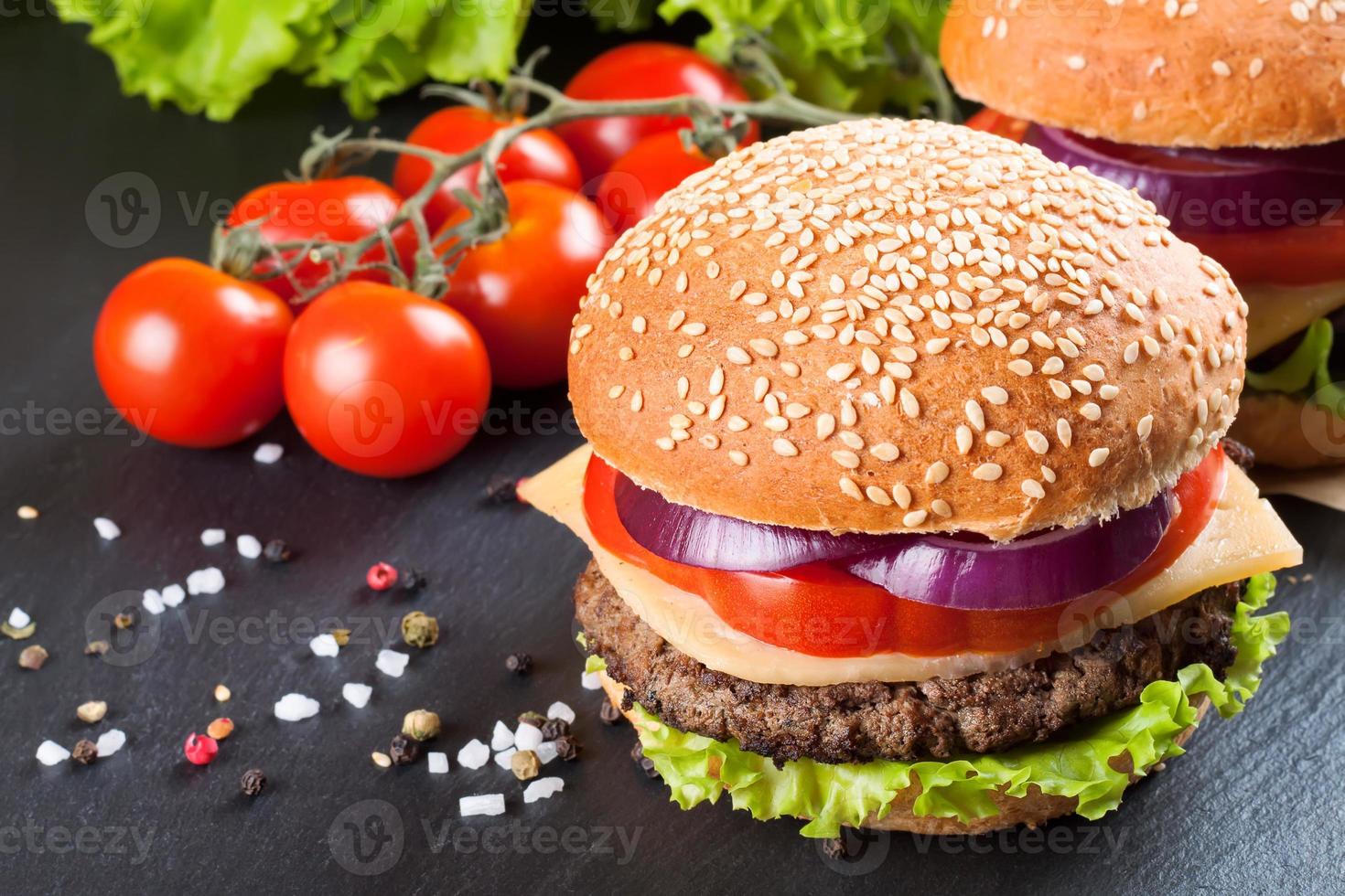 cheeseburger caseiro na superfície de ardósia preta. foto