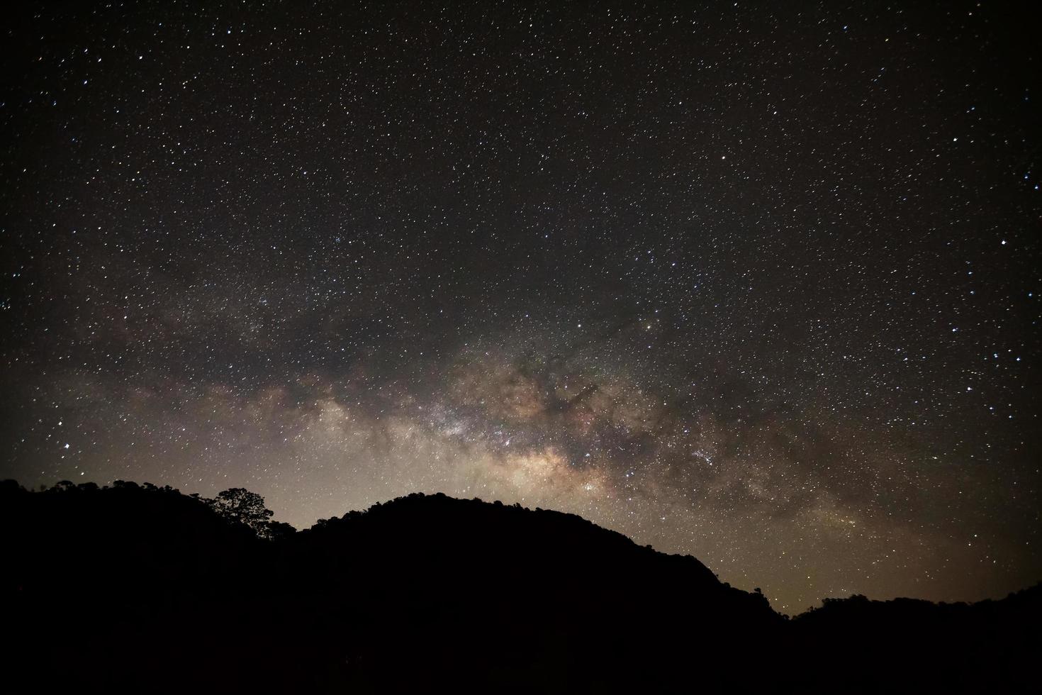 galáxia via láctea na montanha alta de doi luang chiang dao na província de chiang mai, tailândia. fotografia de longa exposição. com grão foto