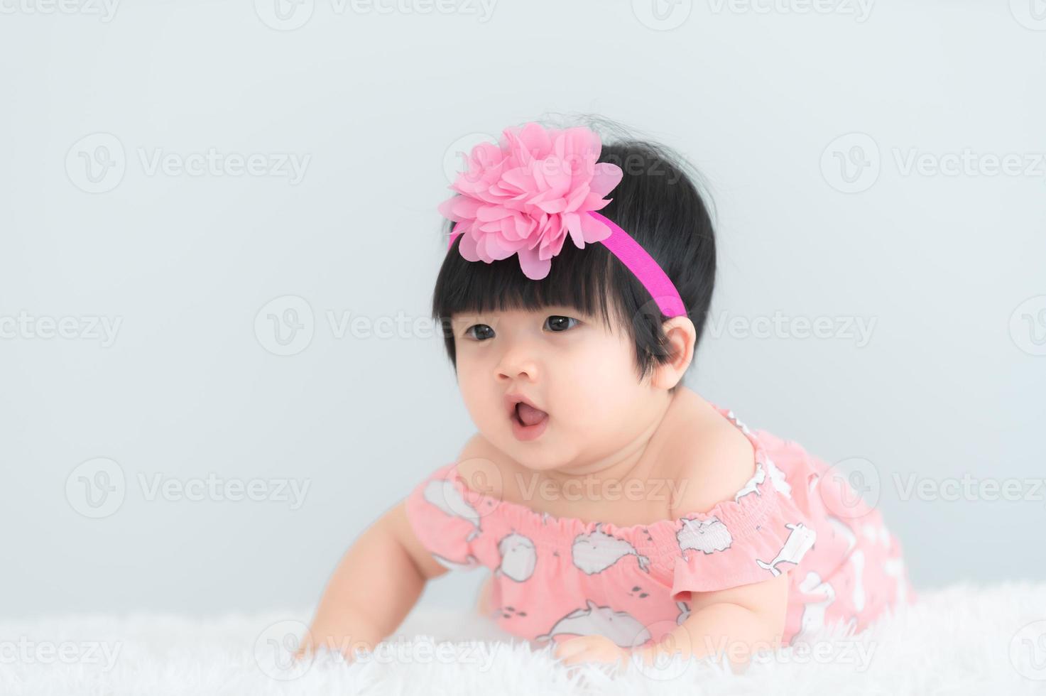 retrato de bebê asiático fofo no tapete branco, sorriso recém-nascido para tirar uma foto