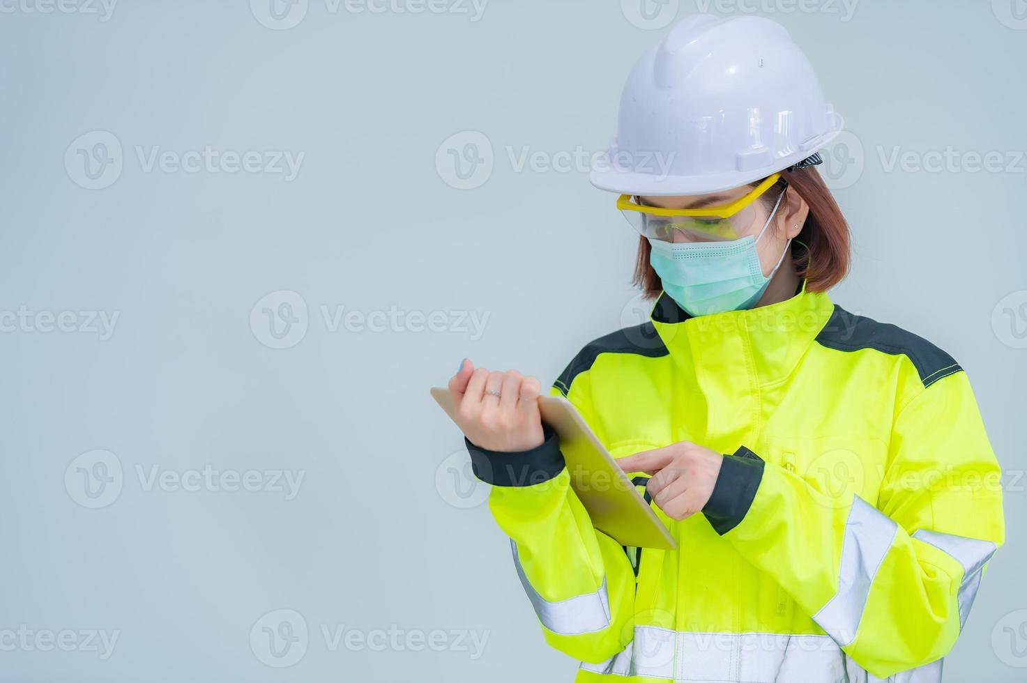 bela engenheira asiática usa terno, óculos e capacete em fundo branco, tailândia foto