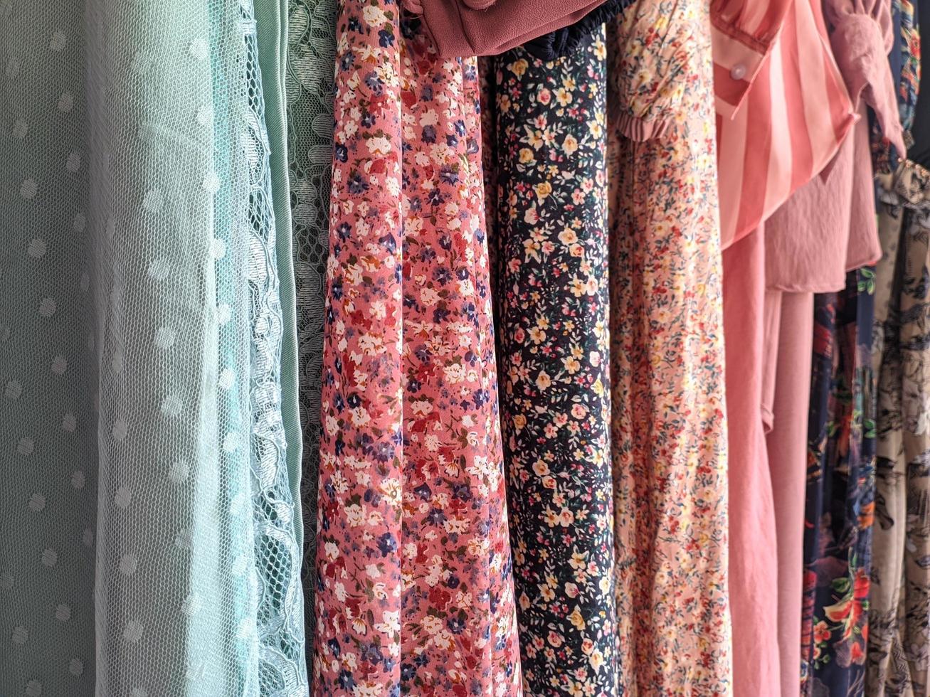 uma coleção de roupas femininas locais penduradas e vendidas em mercados tradicionais com várias cores e motivos foto