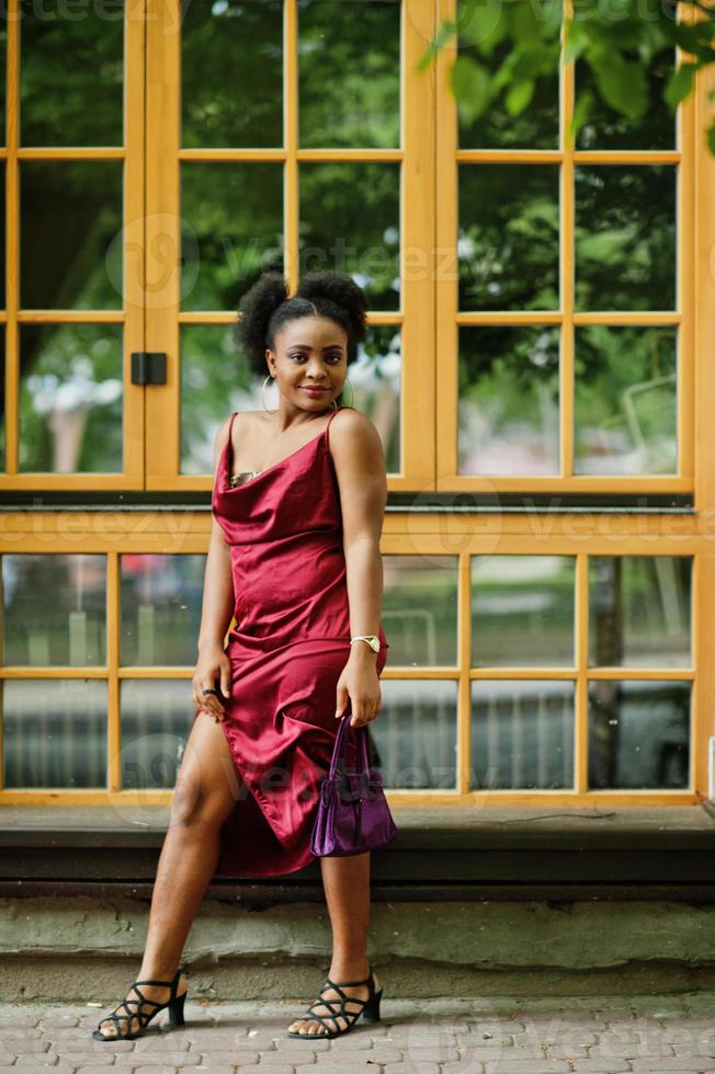 retrato de uma bela jovem africana natural com cabelo afro. modelo preto em vestido de seda vermelho. foto