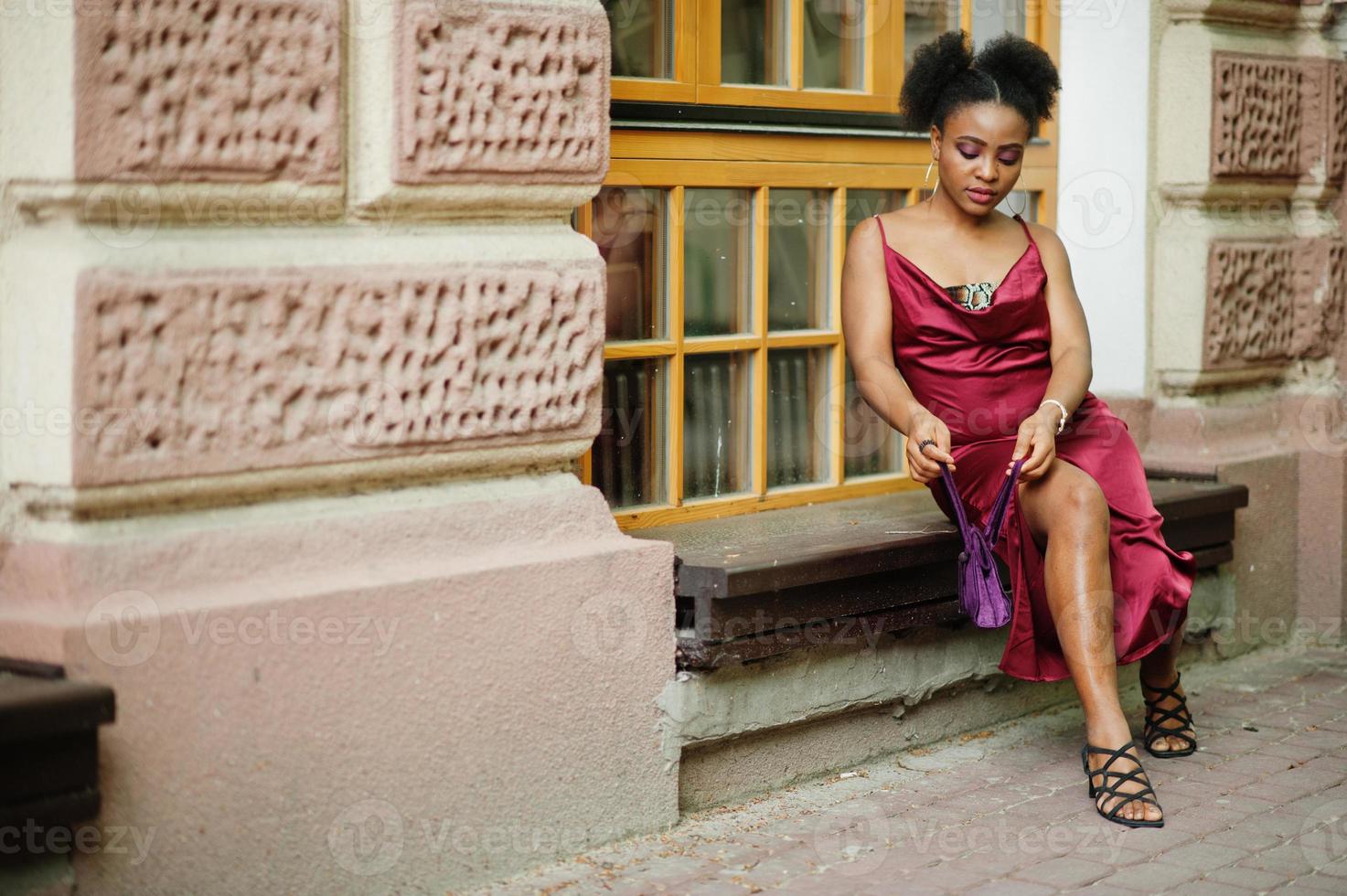 retrato de uma bela jovem africana natural com cabelo afro. modelo preto em vestido de seda vermelho. foto