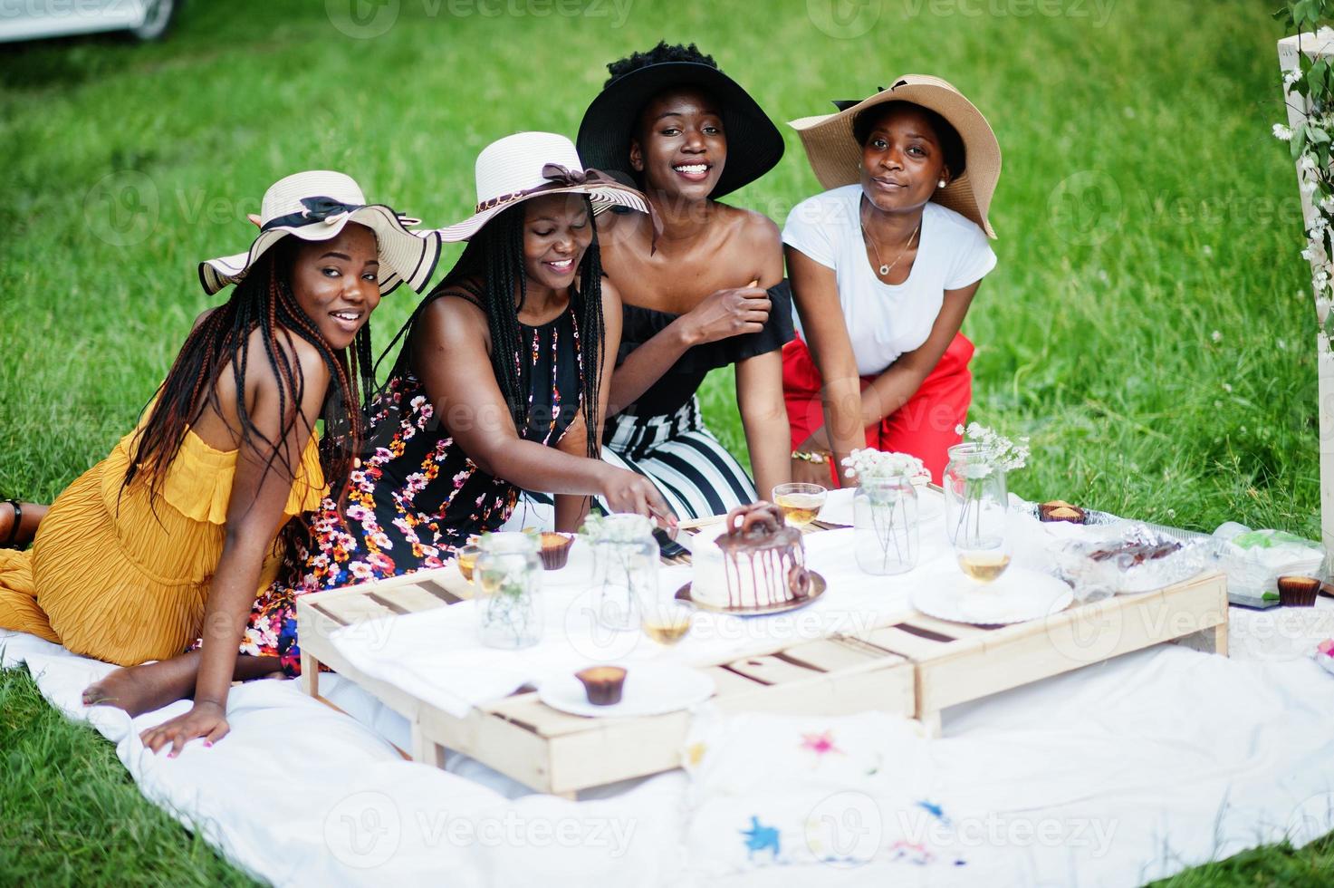 grupo de meninas afro-americanas comemorando festa de aniversário e corte de bolo ao ar livre com decoração. foto