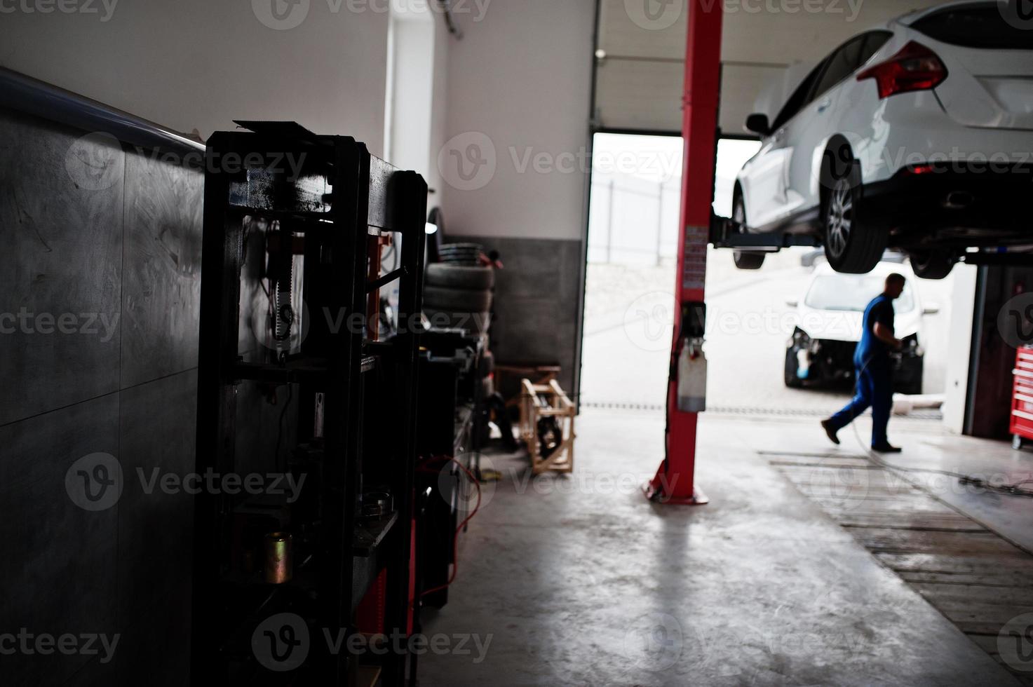 tema de reparação e manutenção de automóveis. mecânico de uniforme trabalhando em auto serviço. foto