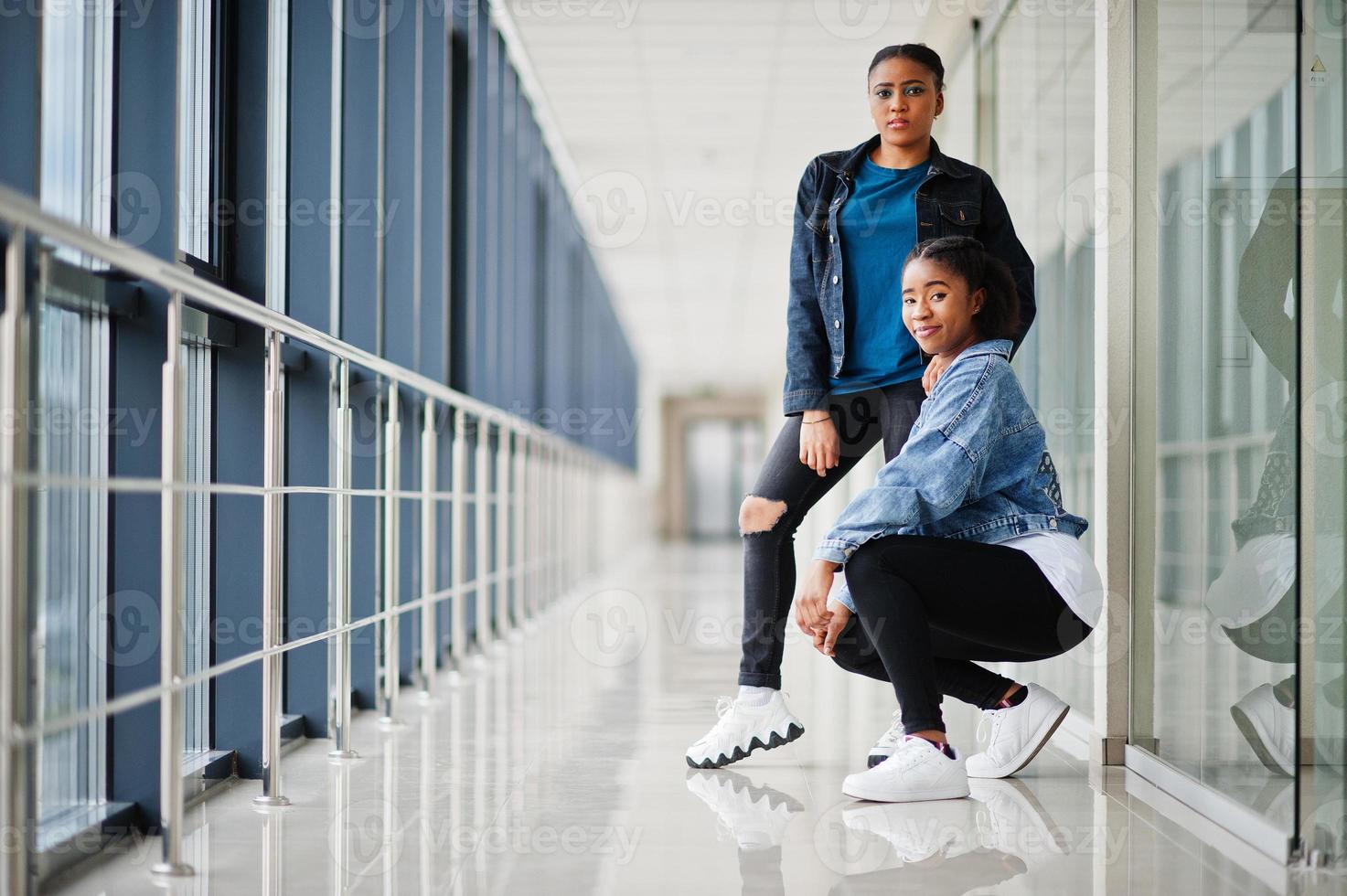 duas amigas africanas de jaqueta jeans posaram juntos no interior. foto