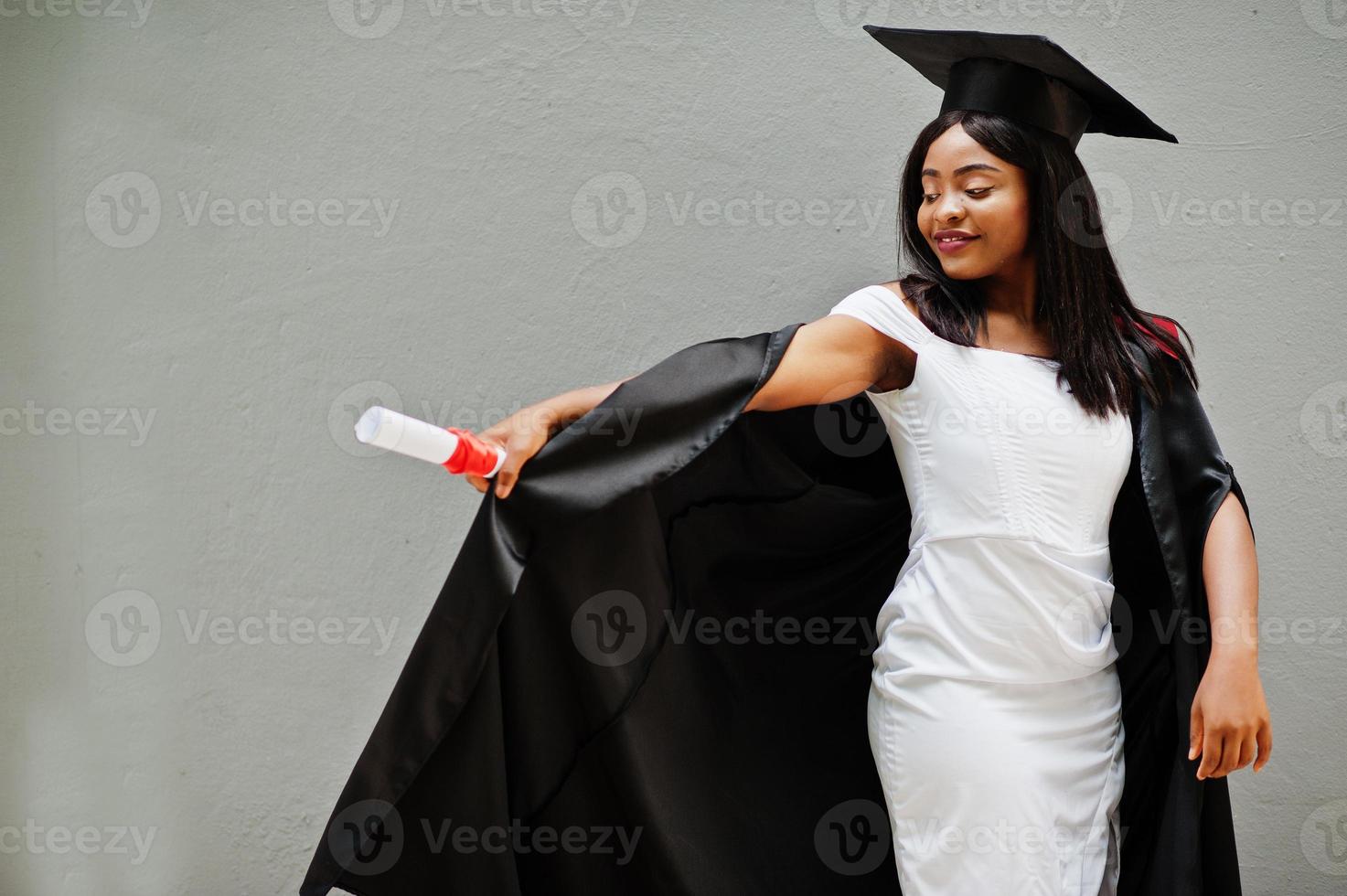 jovem estudante afro-americana com diploma posa ao ar livre. foto