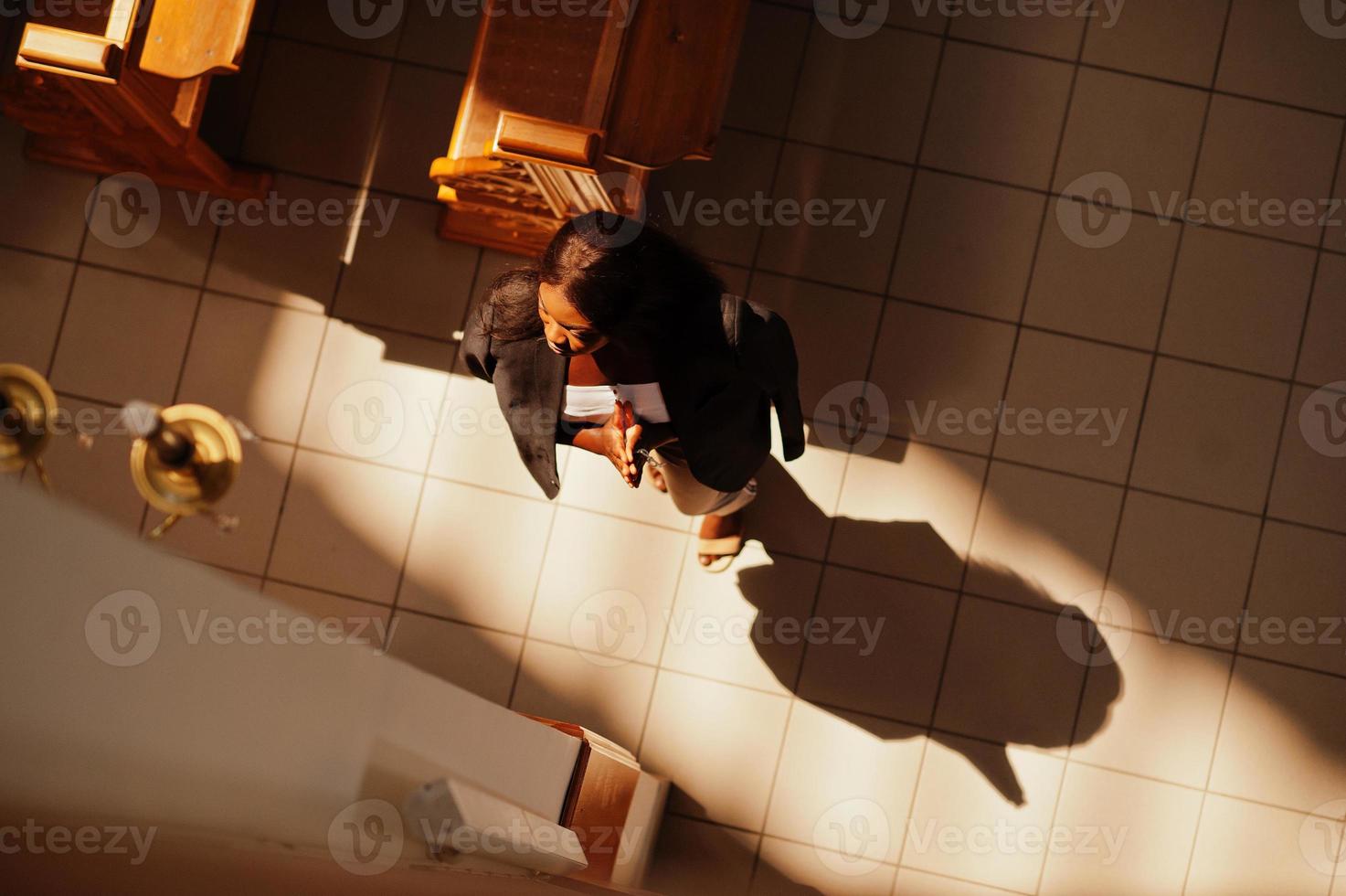 mulher afro-americana rezando na igreja. crentes medita na catedral e tempo espiritual de oração. vista de cima. foto