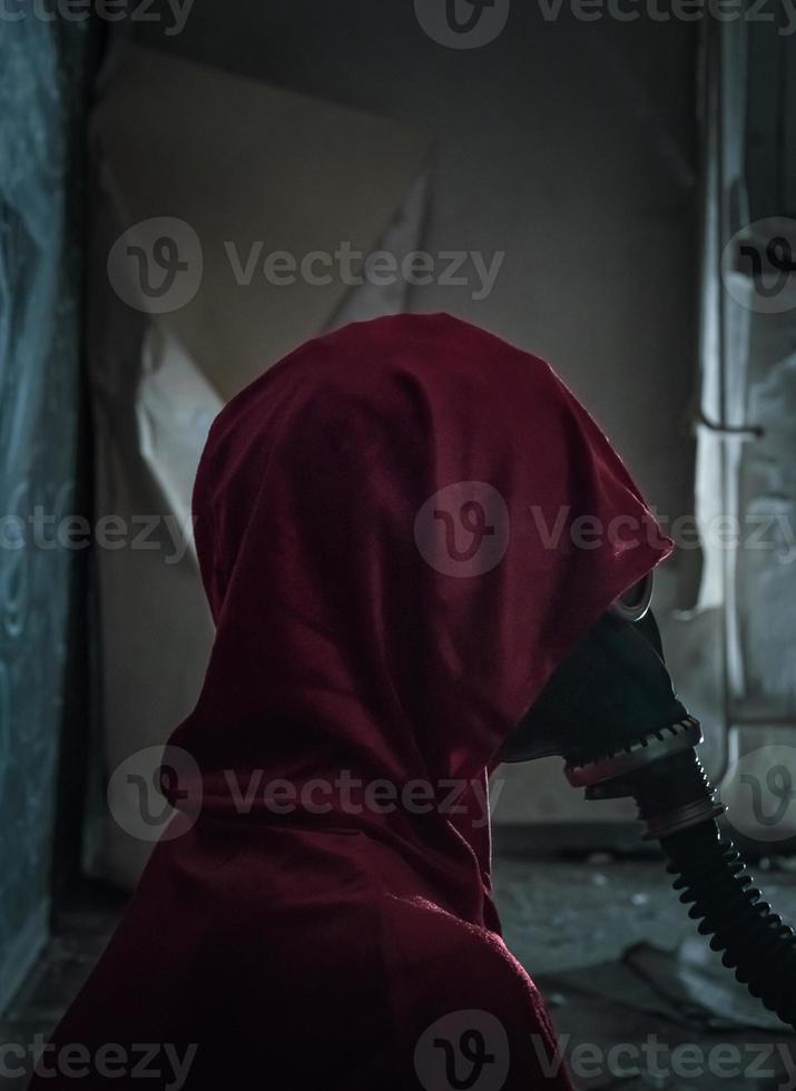 mulher de vestido vermelho usando uma máscara de gás velha foto