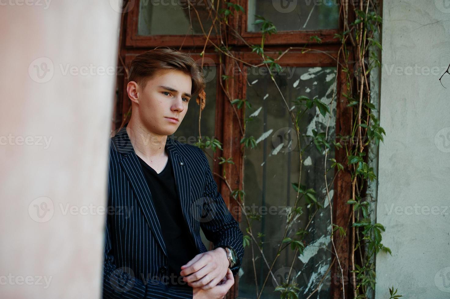 jovem macho macho elegante na jaqueta preta posou ao ar livre da rua. homem modelo incrível. foto