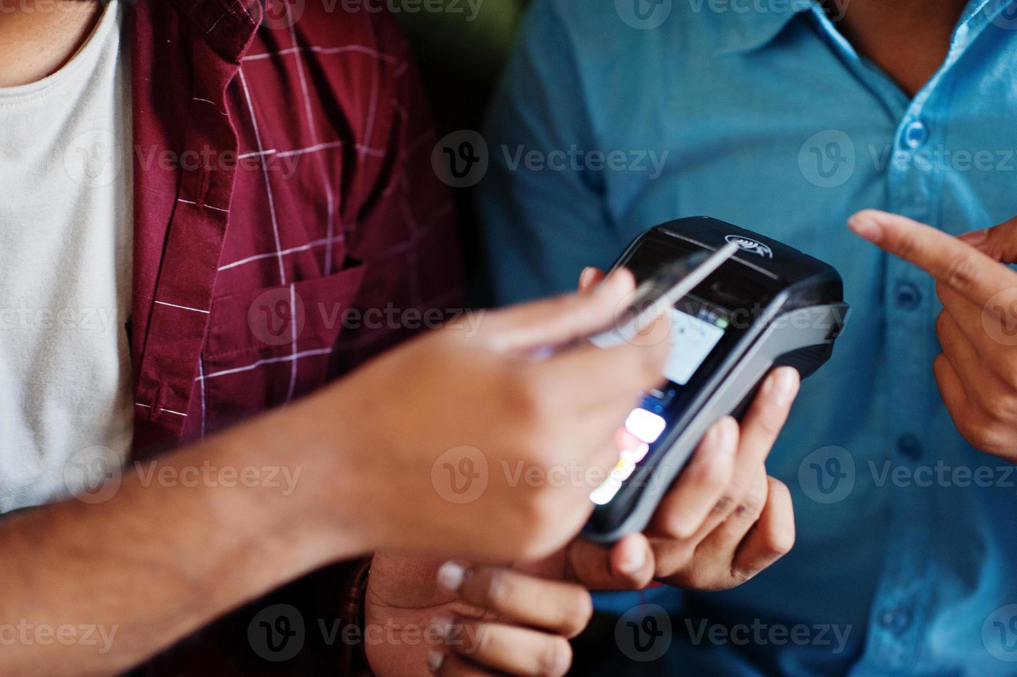 dois clientes estão pagando com cartão de crédito sem contato e terminal de pagamento. foto