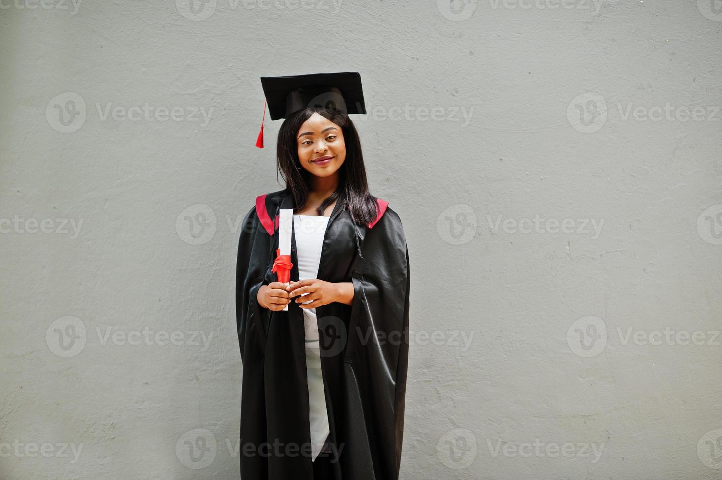 jovem estudante afro-americana com diploma posa ao ar livre. foto