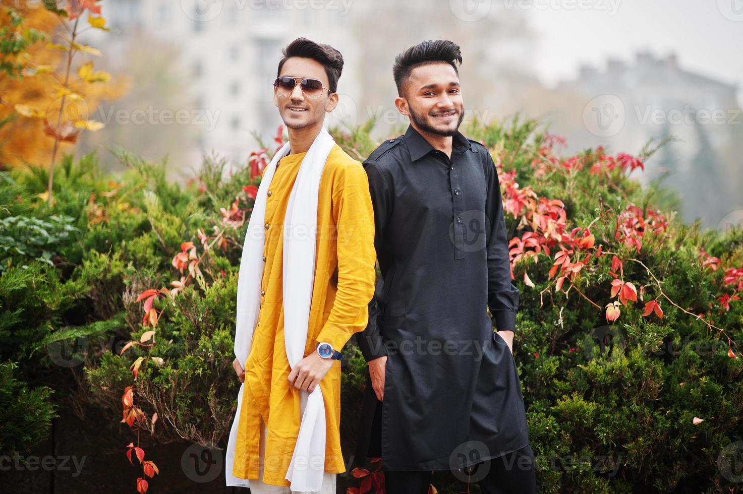 dois amigos indianos elegantes em roupas tradicionais posaram ao ar livre. foto