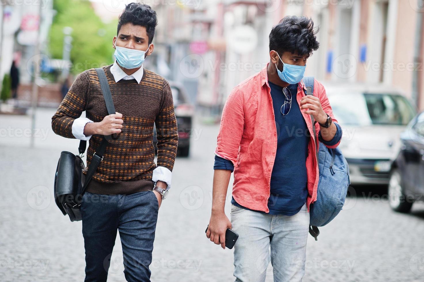 conceito de coronavírus covid-19. dois indianos do sul da Ásia usando máscara para proteger do vírus corona andando na cidade. novo estilo de vida normal pós pandemia na índia. foto