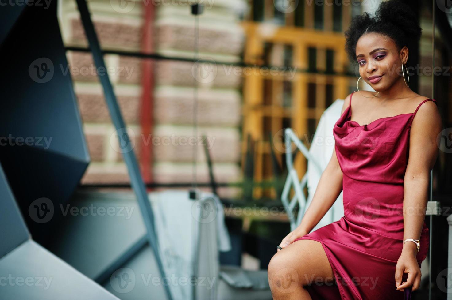 retrato de uma bela jovem africana natural com cabelo afro. modelo preto em vestido de seda vermelho. foto