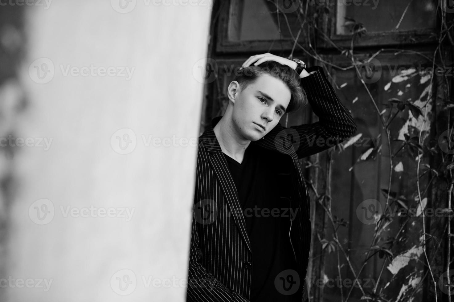 jovem macho macho elegante na jaqueta preta posou ao ar livre da rua. homem modelo incrível. foto