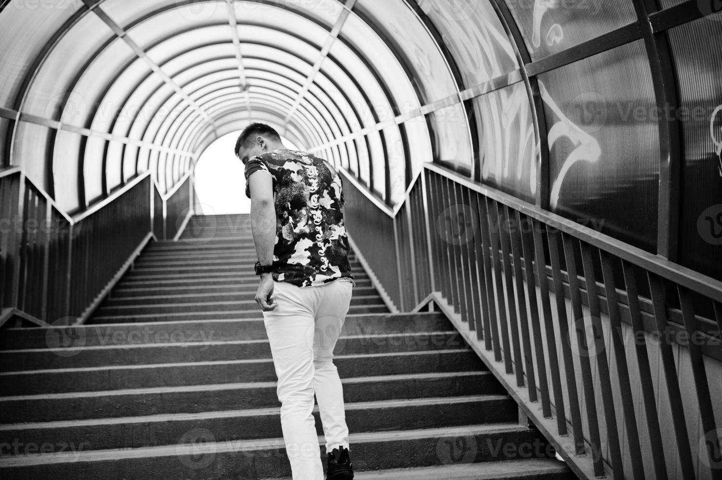 retrato de estilo de vida de homem bonito posando em escadas vermelhas do tonel da cidade. foto