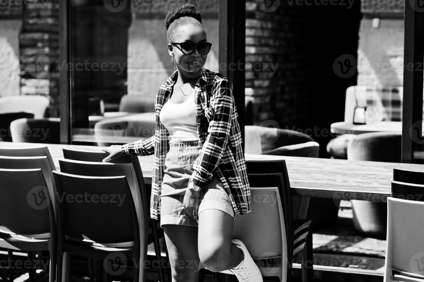 garota afro-americana de hip hop em shorts jeans e óculos de sol. retrato de moda de rua casual de mulher negra. foto