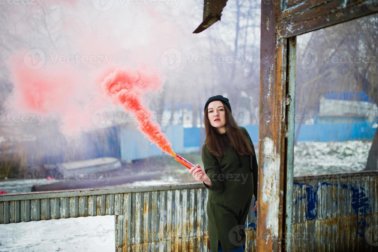 jovem com bomba de fumaça de cor vermelha na mão. foto