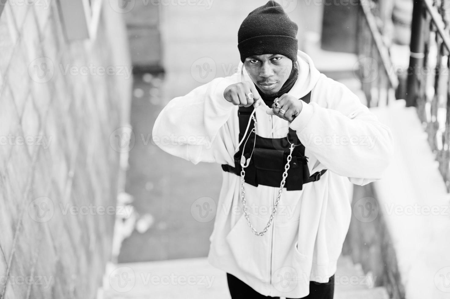 homem afro-americano de estilo urbano elegante com capuz rosa posou no dia de inverno e mãos de boxe. foto