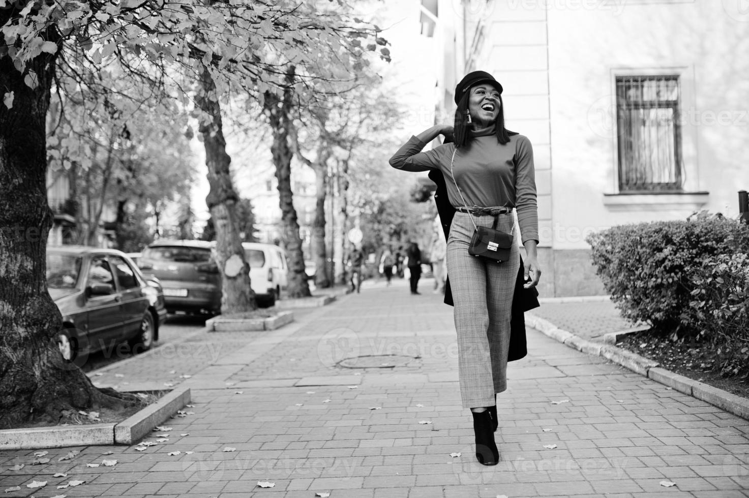 garota de moda afro-americana de casaco e boné de jornaleiro posou na rua. foto