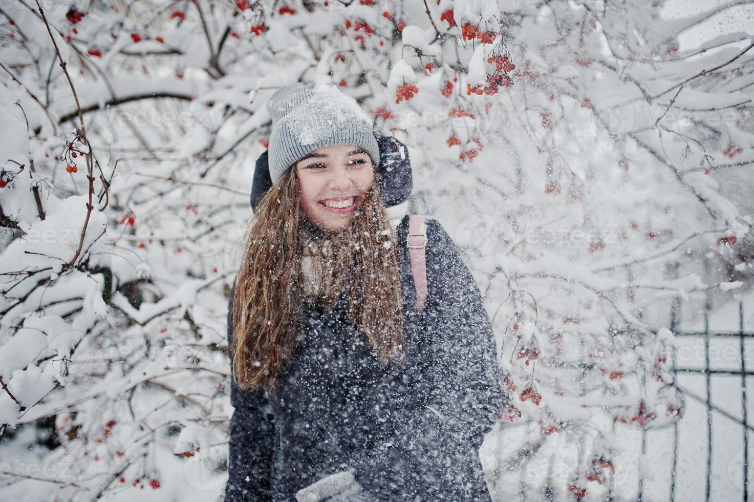 retrato de menina no dia de inverno nevado perto de árvores cobertas de neve. foto