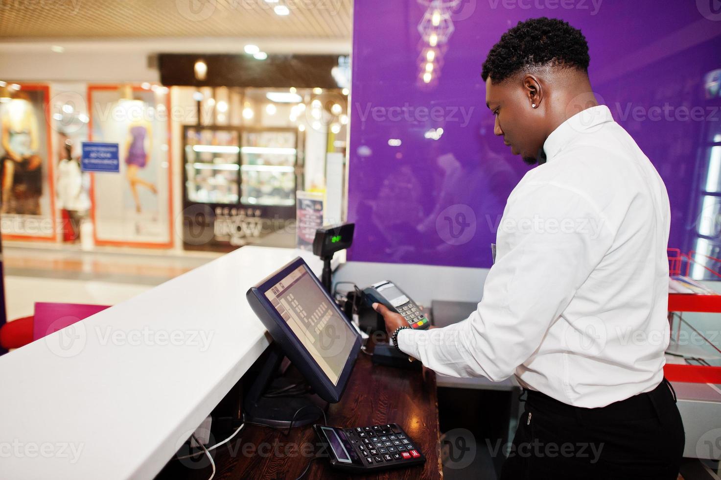 barman americano africano no bar usa um terminal de cartão de crédito no caixa. foto