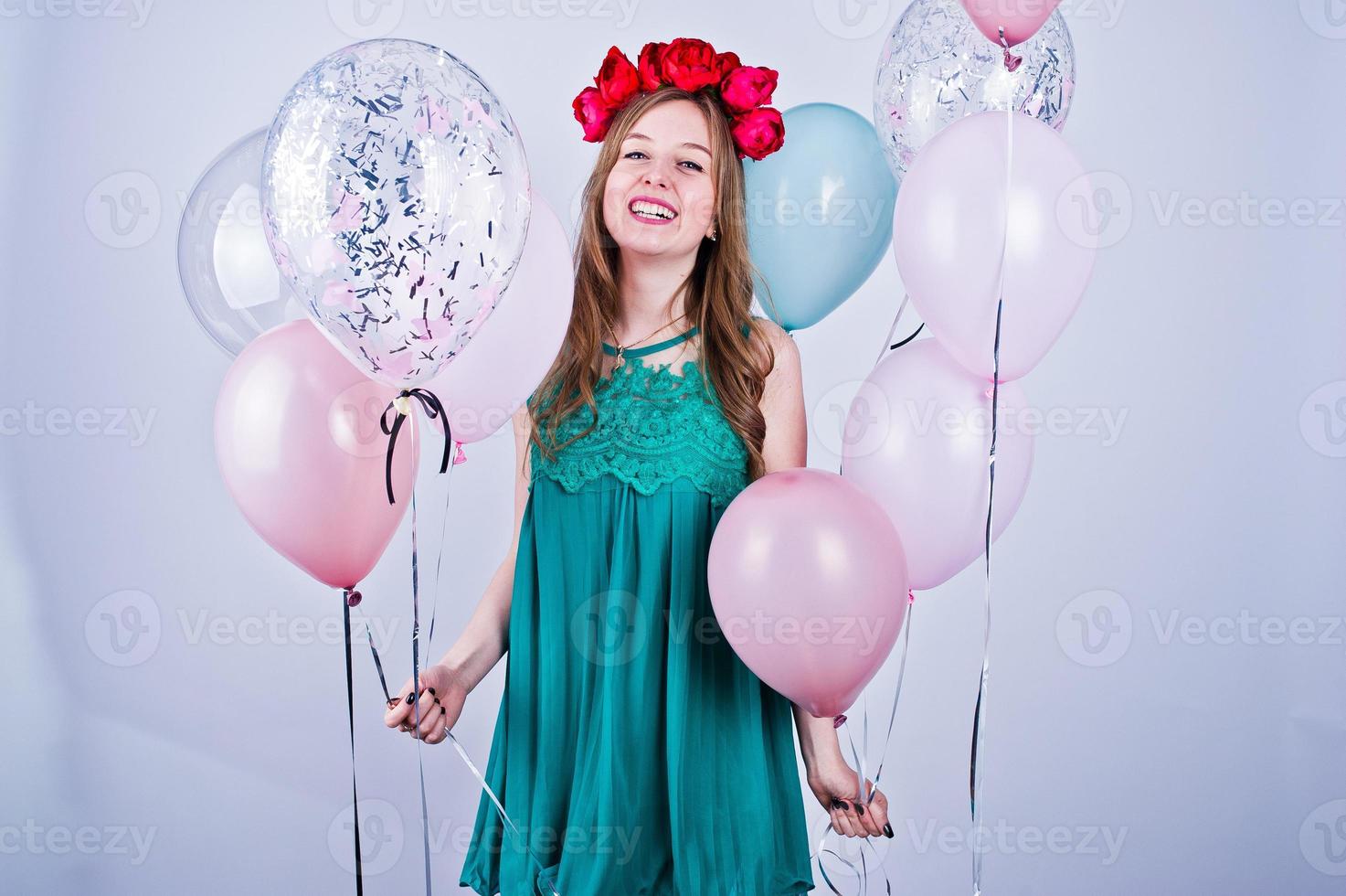 garota feliz no vestido verde turquesa e grinalda com balões coloridos isolados no branco. comemorando o tema do aniversário. foto