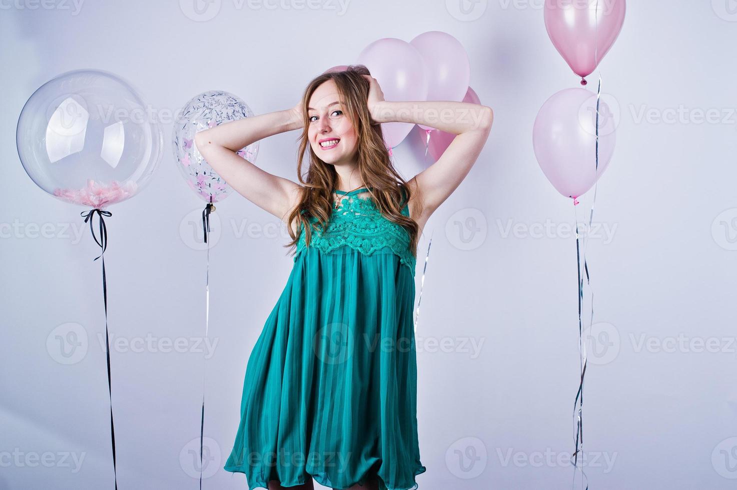 garota feliz no vestido verde turquesa com balões coloridos isolados no branco. comemorando o tema do aniversário. foto