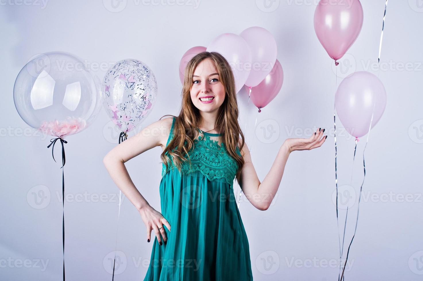 garota feliz no vestido verde turquesa com balões coloridos isolados no branco. comemorando o tema do aniversário. foto