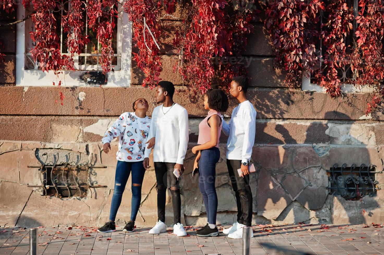 quatro amigos africanos andando pelas ruas de uma cidade antiga. foto