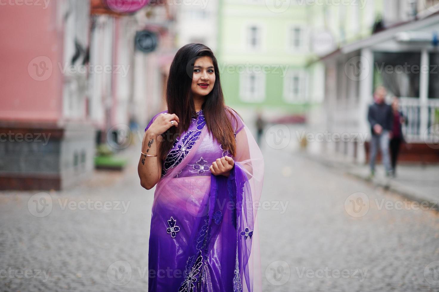 garota hindu indiana no saree violeta tradicional posou na rua. foto