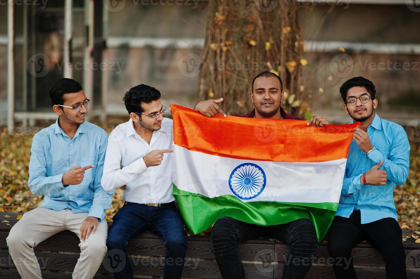 grupo de quatro homens indianos do sul da Ásia com bandeira da índia. foto