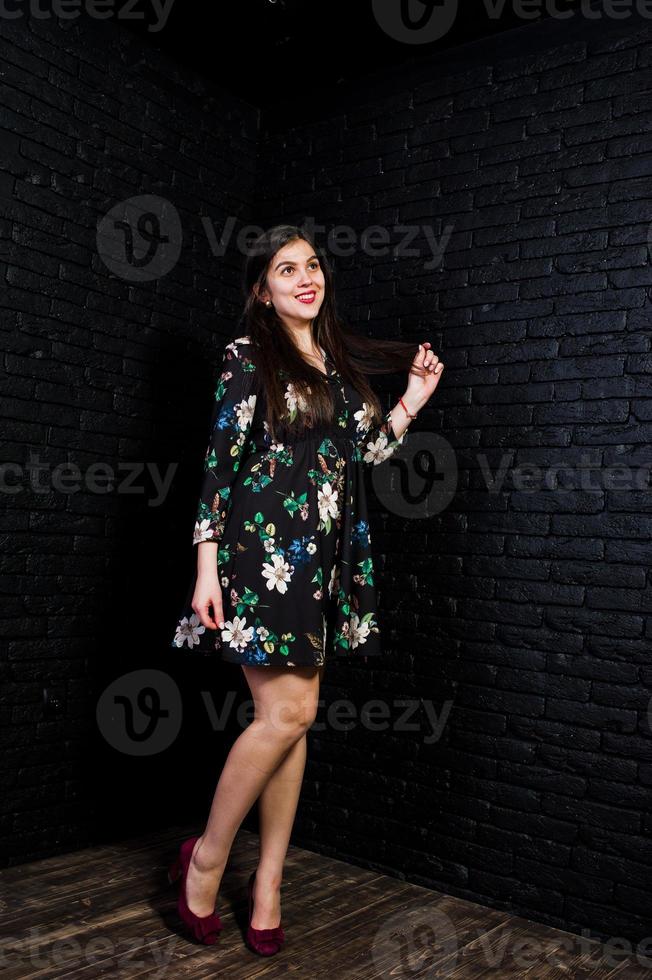 retrato de uma jovem fabulosa em vestido floral no estúdio escuro. foto