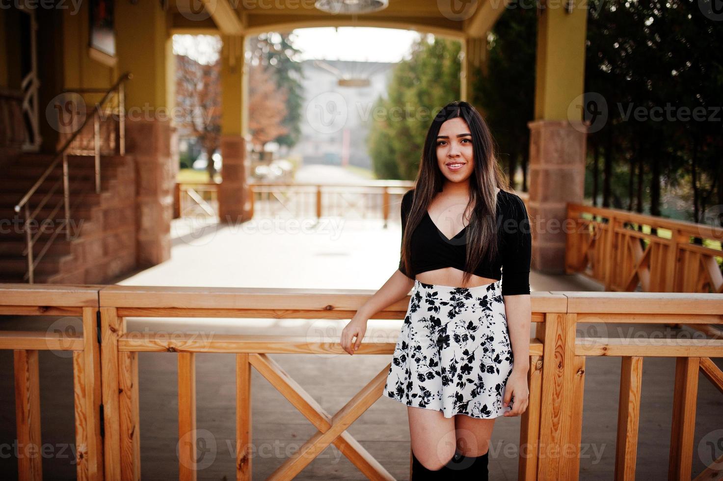 menina bonita modelo latino do Equador usar tops pretos e saia posada na rua. foto