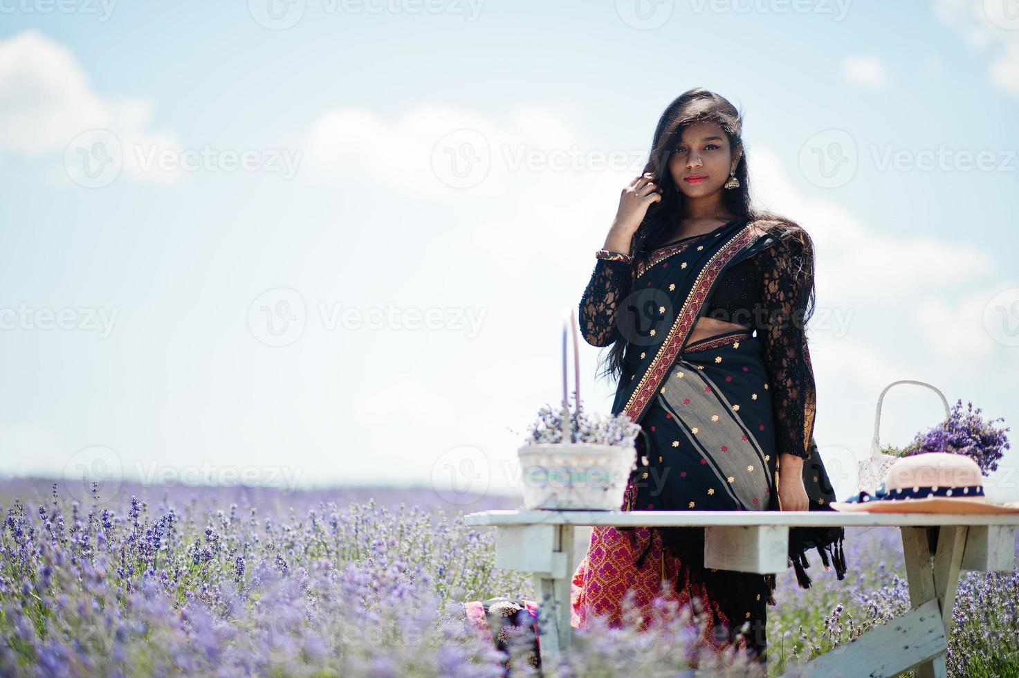 linda garota indiana usar vestido tradicional saree índia no campo de lavanda roxo. foto