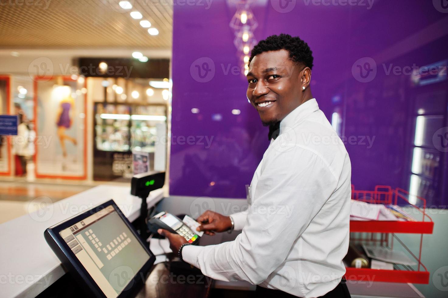 barman americano africano no bar usa um terminal de cartão de crédito no caixa. foto