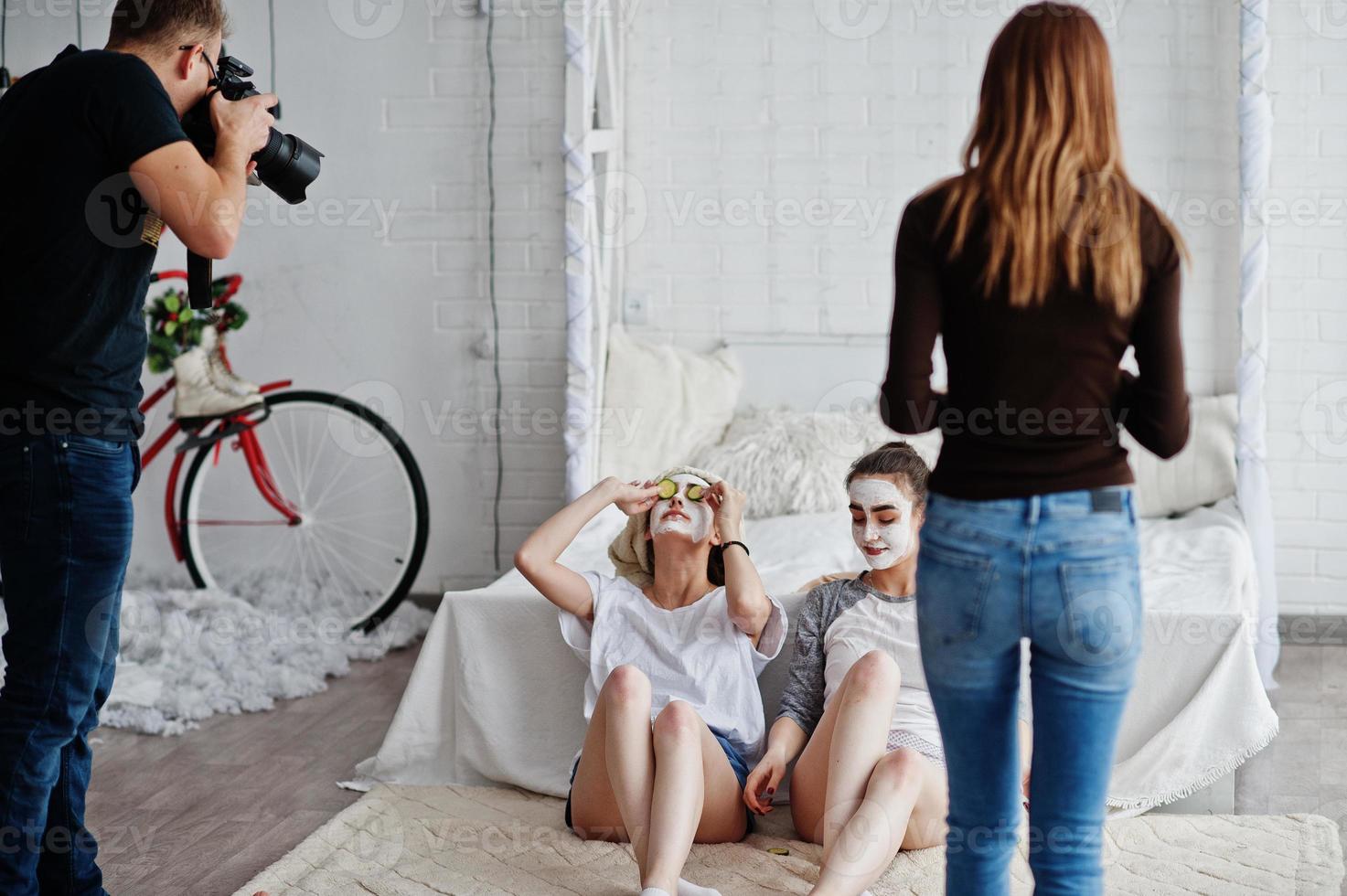 a equipe de dois fotógrafos fotografando garotas gêmeas de estúdio enquanto elas fazem seu próprio creme de máscaras. fotógrafo profissional no trabalho. foto