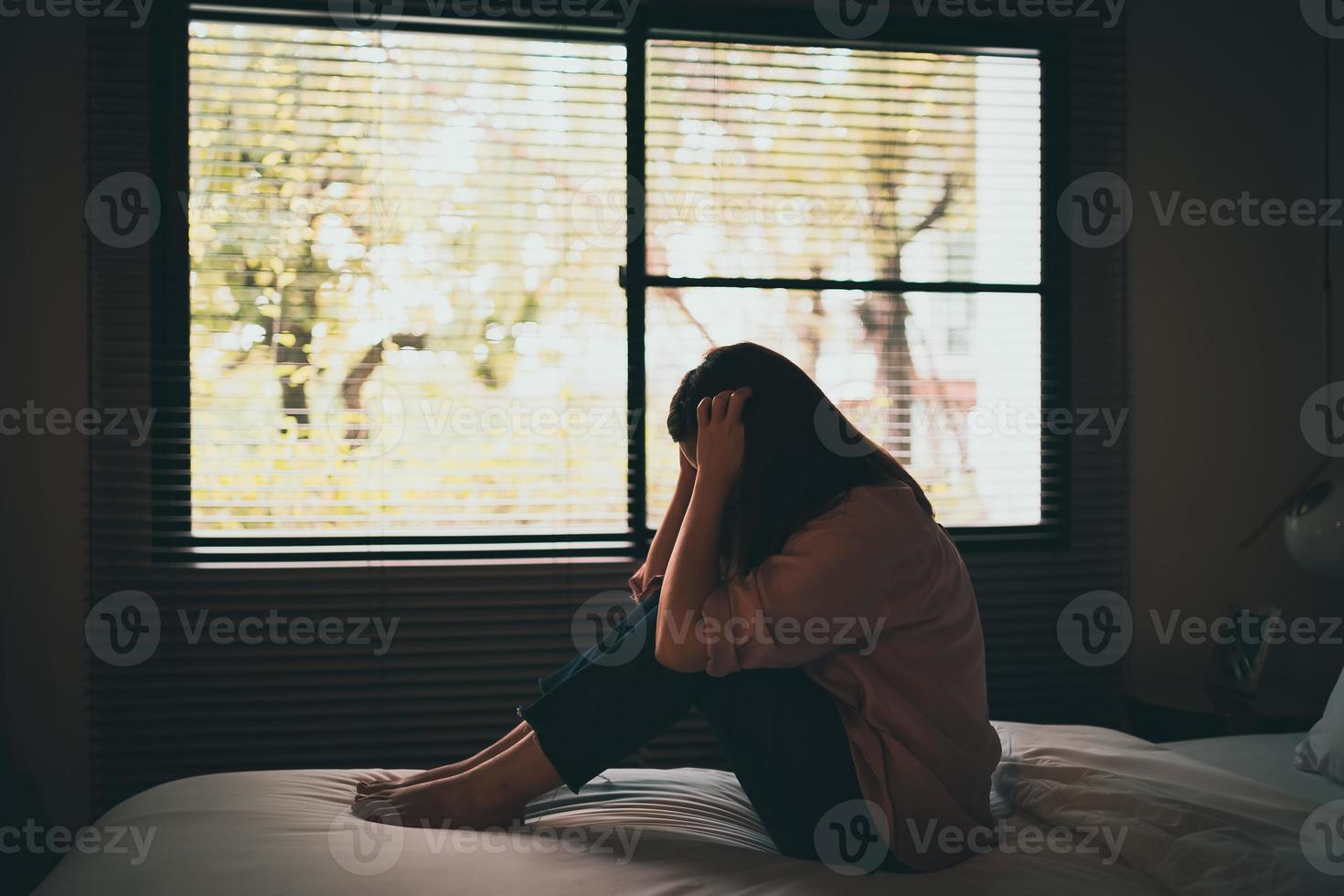 triste mulher asiática que sofre de depressão insônia acordada e sente-se sozinha na cama no quarto. assédio sexual e violência contra as mulheres, conceito de saúde foto