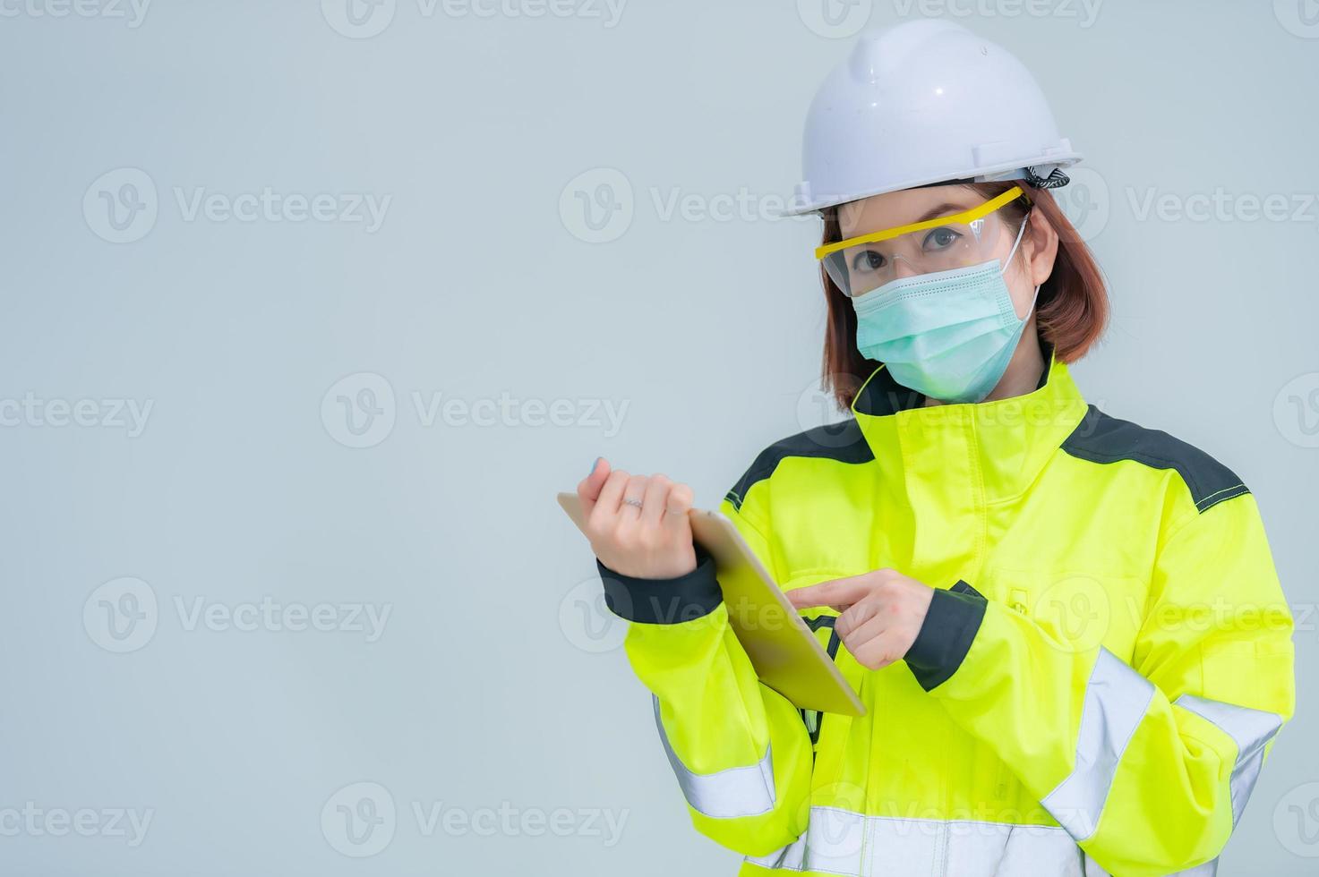 bela engenheira asiática usa terno, óculos e capacete em fundo branco, tailândia foto