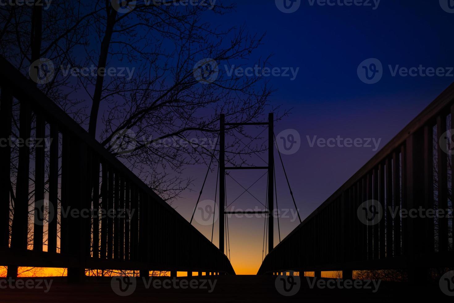 vista de ângulo baixo de uma ponte em silhueta ao pôr do sol foto