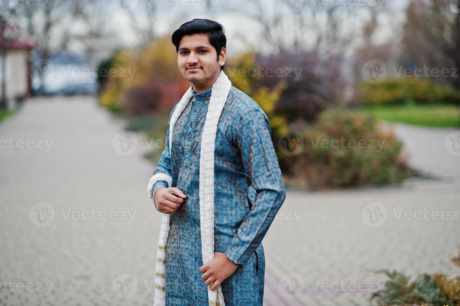 homem indiano usa roupas tradicionais com lenço branco posado ao ar livre. foto