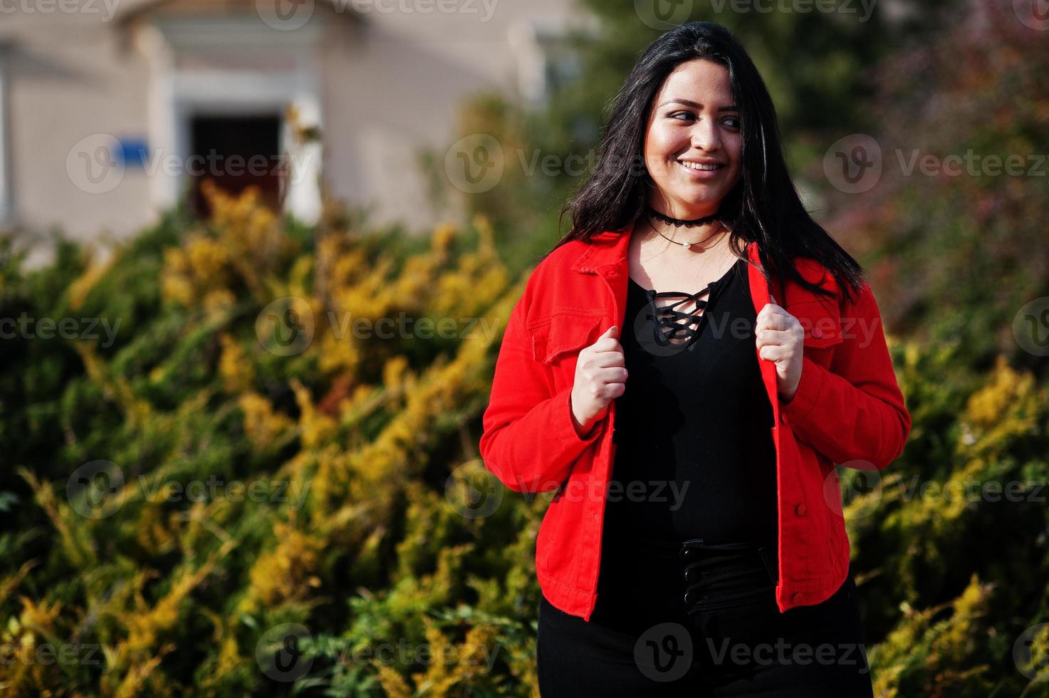 menina bonita modelo latino do Equador veste jaqueta preta e vermelha posada na rua. foto