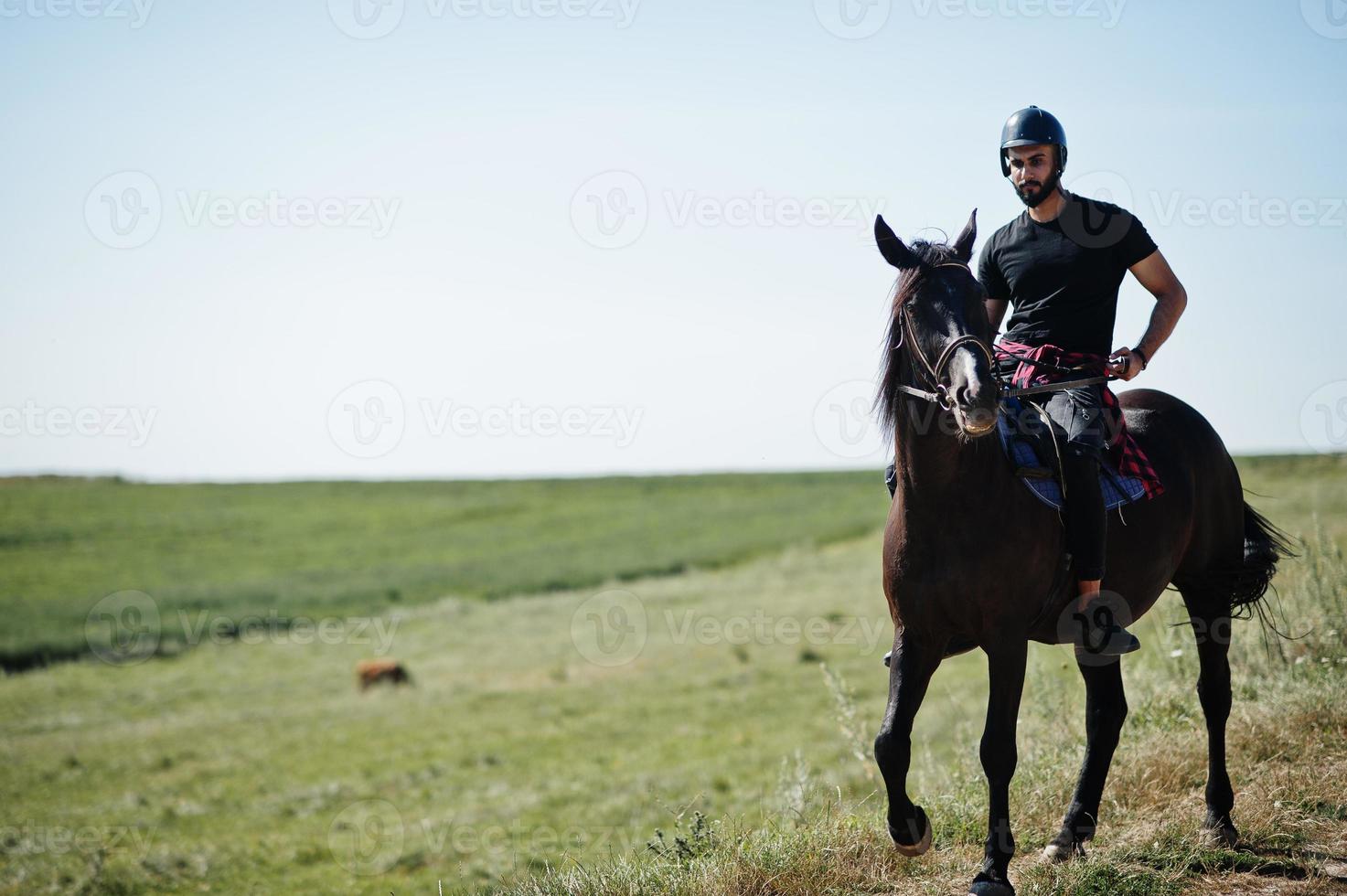 homem de barba alta árabe usar capacete preto, cavalgar cavalo árabe. foto