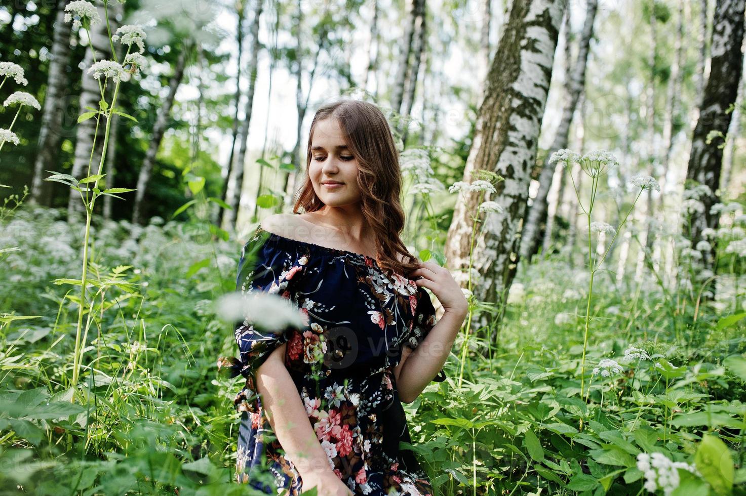 retrato de uma jovem fabulosa em um vestido bonito com elegante penteado encaracolado posando na floresta ou no parque. foto