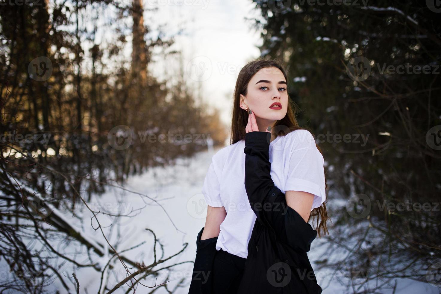 modelo morena de pernas longas na moda no manto preto longo posou ao ar livre no dia de inverno. foto