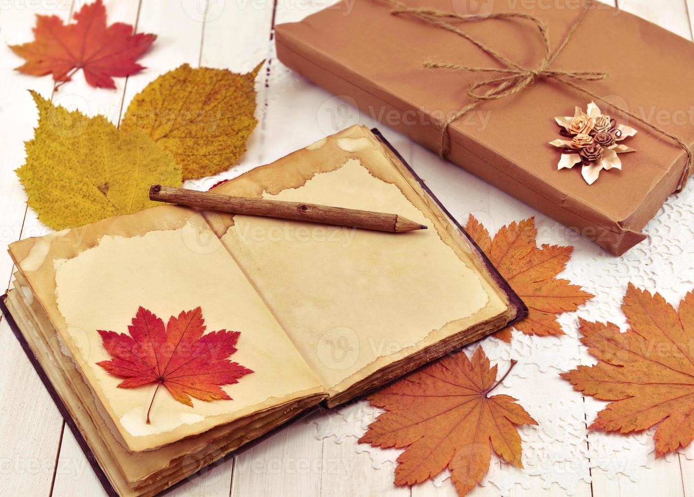 outono ainda vida com livro, folhas e presente embrulhado foto