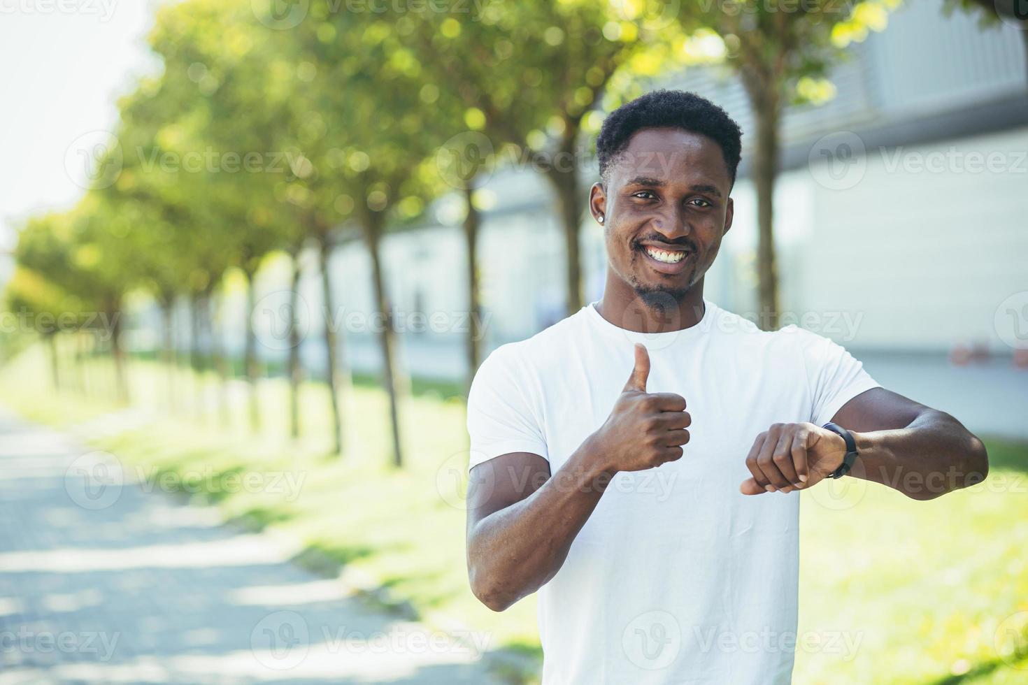 um jovem afro-americano, em uma corrida matinal em uma camiseta branca no parque, satisfeito foto